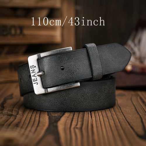 A black textured leather belt with a silver-toned rectangular buckle engraved with 'JEANS', coiled on a rustic wooden surface. 
110cm/43inch